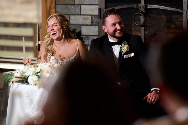 Carlee and Tayven laughing at their table during the toasts