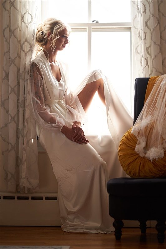 A bride at the window while everyone is still getting ready
