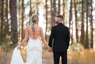 bride and groom holding hands in a forest, photographed for Complete Weddings & Events, black hills receptions wedding, photographer near me, black hills wedding, fall wedding