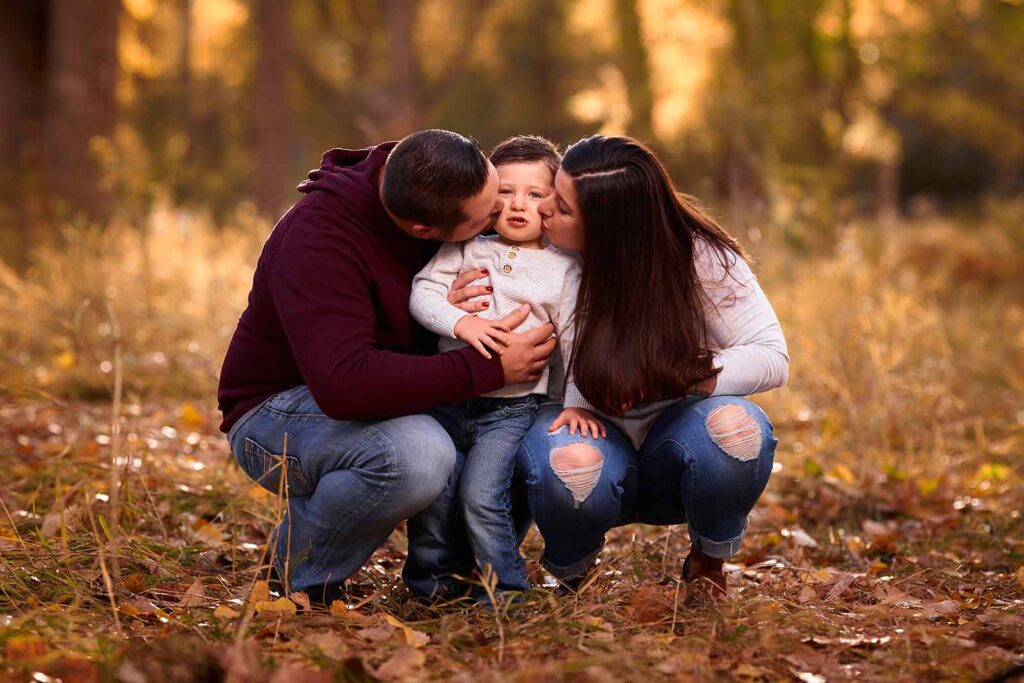 canyon lake family photo session, couple kissing their child