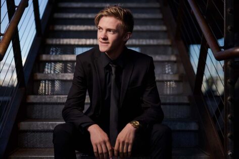 high school senior boy in a suit sitting on the stairs, rapid city senior photographer