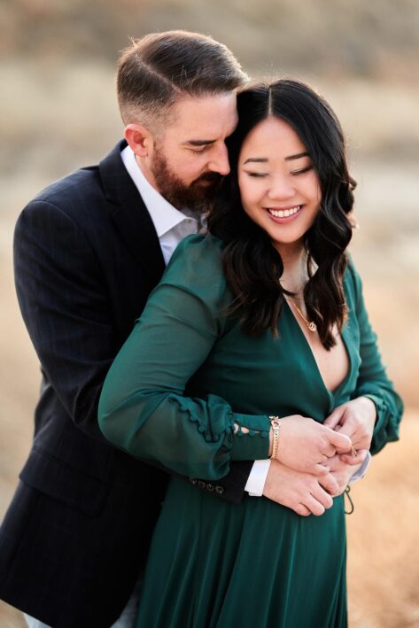 man holding woman from behind, badlands engagement photos