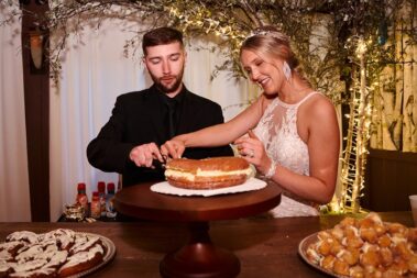 bride and groom cut donut cake, photographed for Complete Weddings & Events, black hills receptions wedding, photographer near me, black hills wedding, fall wedding