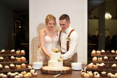bride and groom cutting cake, winter wedding, photographed for Complete Weddings & Events, black hills barn wedding, barn at aspen acres wedding, spearfish wedding
