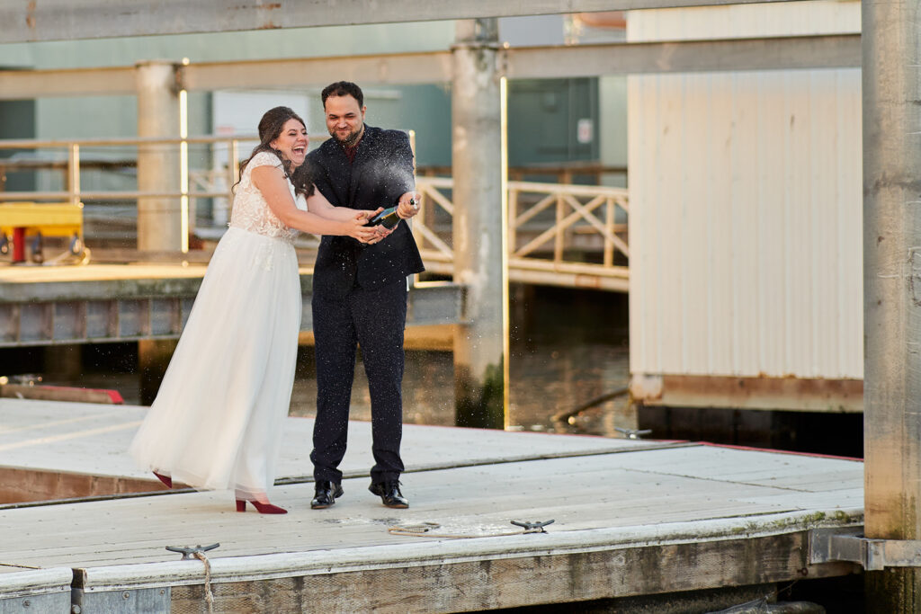 couple popping champagne on a dock, black hills engagement photos