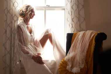 bride sitting on a window sill