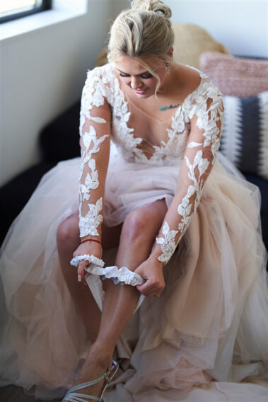 bride putting on garter barn at aspen acres wedding black hills barn