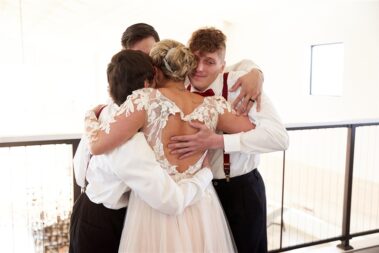 bride hugging brothers barn at aspen acres wedding black hills barn